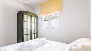 Una habitación con cama, armario y ventana con vistas.