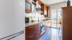 Una cocina moderna con armarios de madera, un microondas integrado y una estufa.