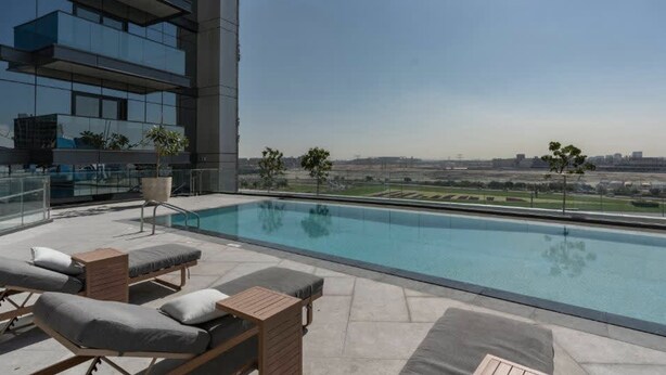 A rooftop pool with lounge chairs and a view of a cityscape. - Stayshort - 1 Bed in Business Bay Sleeps 2 With City Views (Dubai)