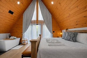 Un dormitorio acogedor con paneles de madera, una cama, mesitas de noche y un banco.