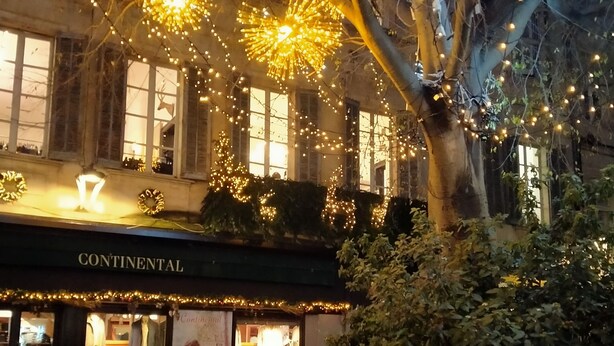 Une devanture de magasin avec une enseigne indiquant « Continental », un vélo garé à l’extérieur et une plaque signalétique pour « Maison Isabel Golden ».