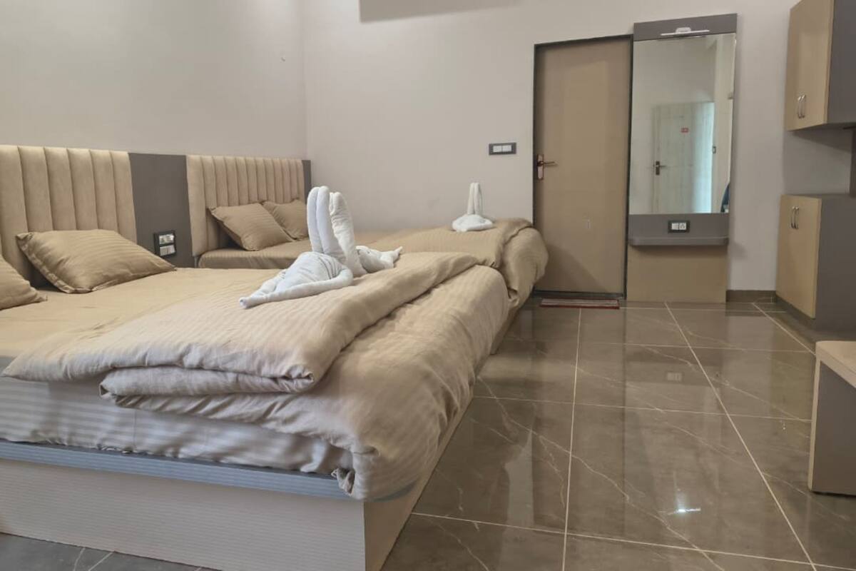 A modern hotel room with a large bed, a wardrobe, and a bathroom.