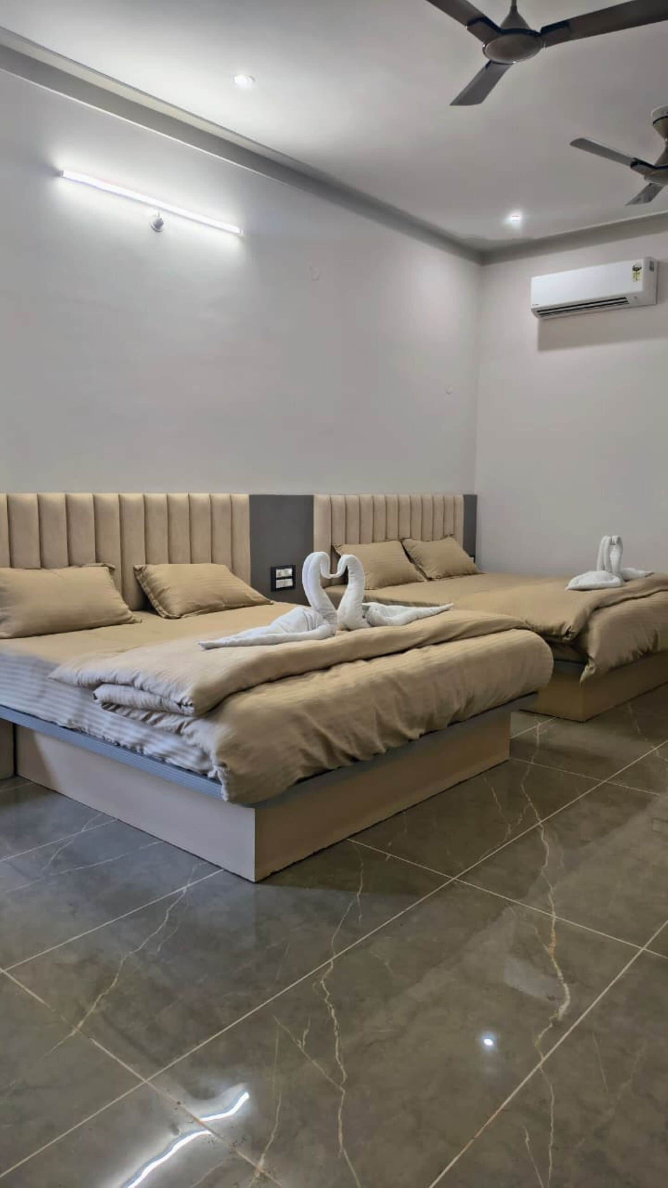 Une chambre d’hôtel moderne dotée d’un grand lit, d’un ventilateur de plafond et d’un appareil de climatisation.