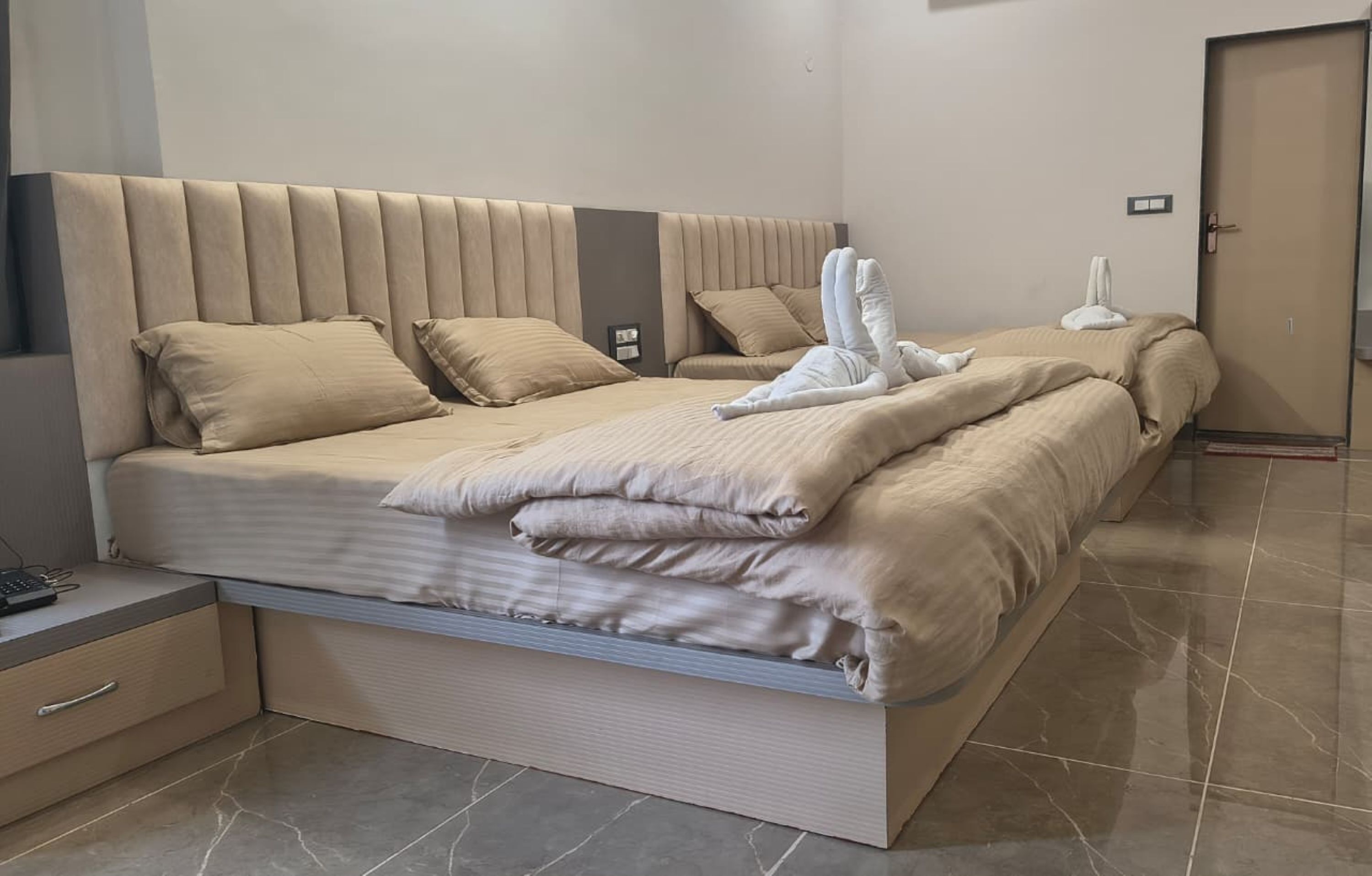 Quarto de hotel moderno com uma cama grande, uma mesa de cabeceira e um guarda-roupa.