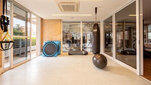 Un gimnasio espacioso con equipamiento de ejercicio, ventanas amplias y un diseño interior moderno.