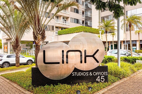A sign for 'LINK Studios & Offices 45' with a modern building in the background. - Premium Modern Studio in Alphaville (Santana de Parnaíba)