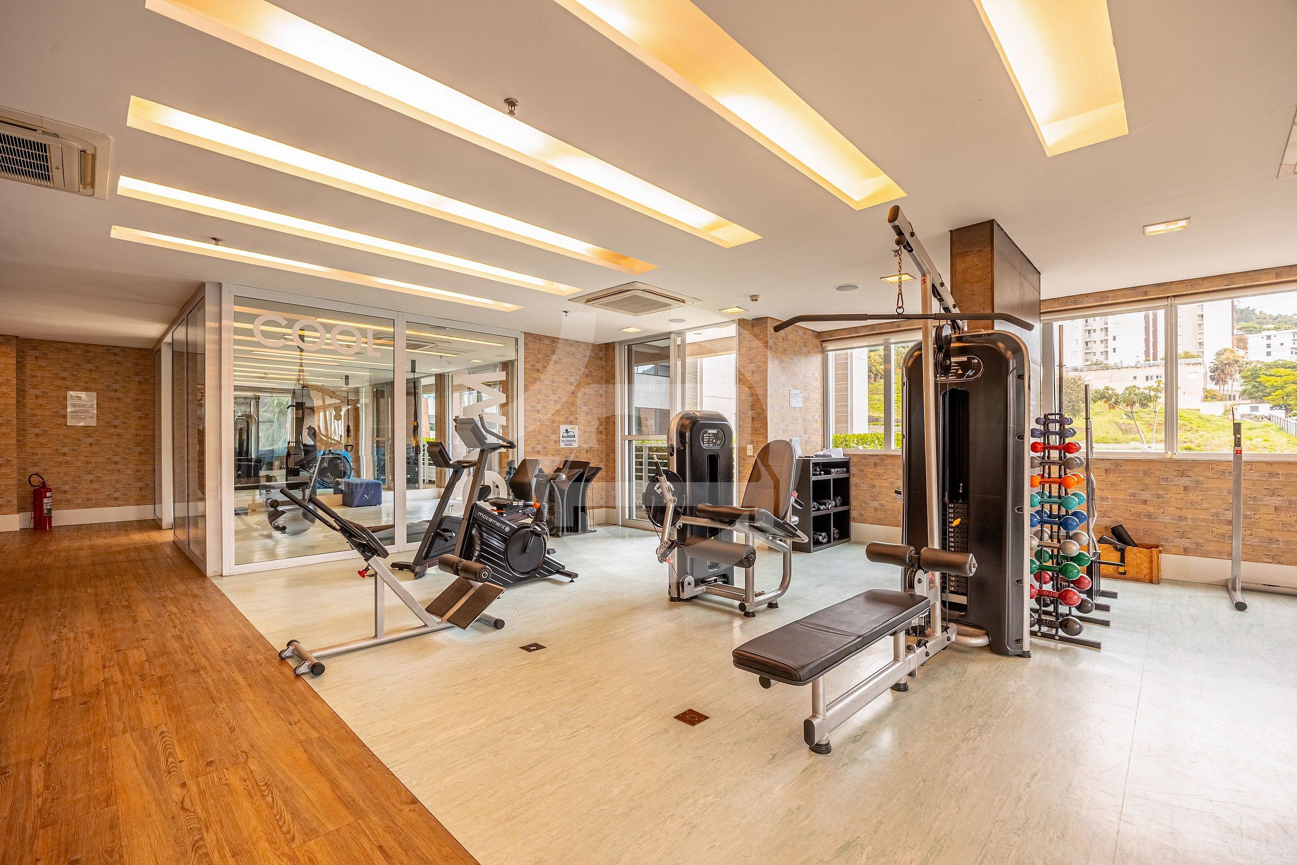 Ett gym med träningsredskap, en bänk och ett ställ för vikter.
