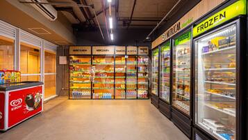 Et supermarked indvendigt, med kølediske mærket 'FROZEN' og 'NUTRICAR'. Hylderne er fyldt med forskellige fødevarer.
