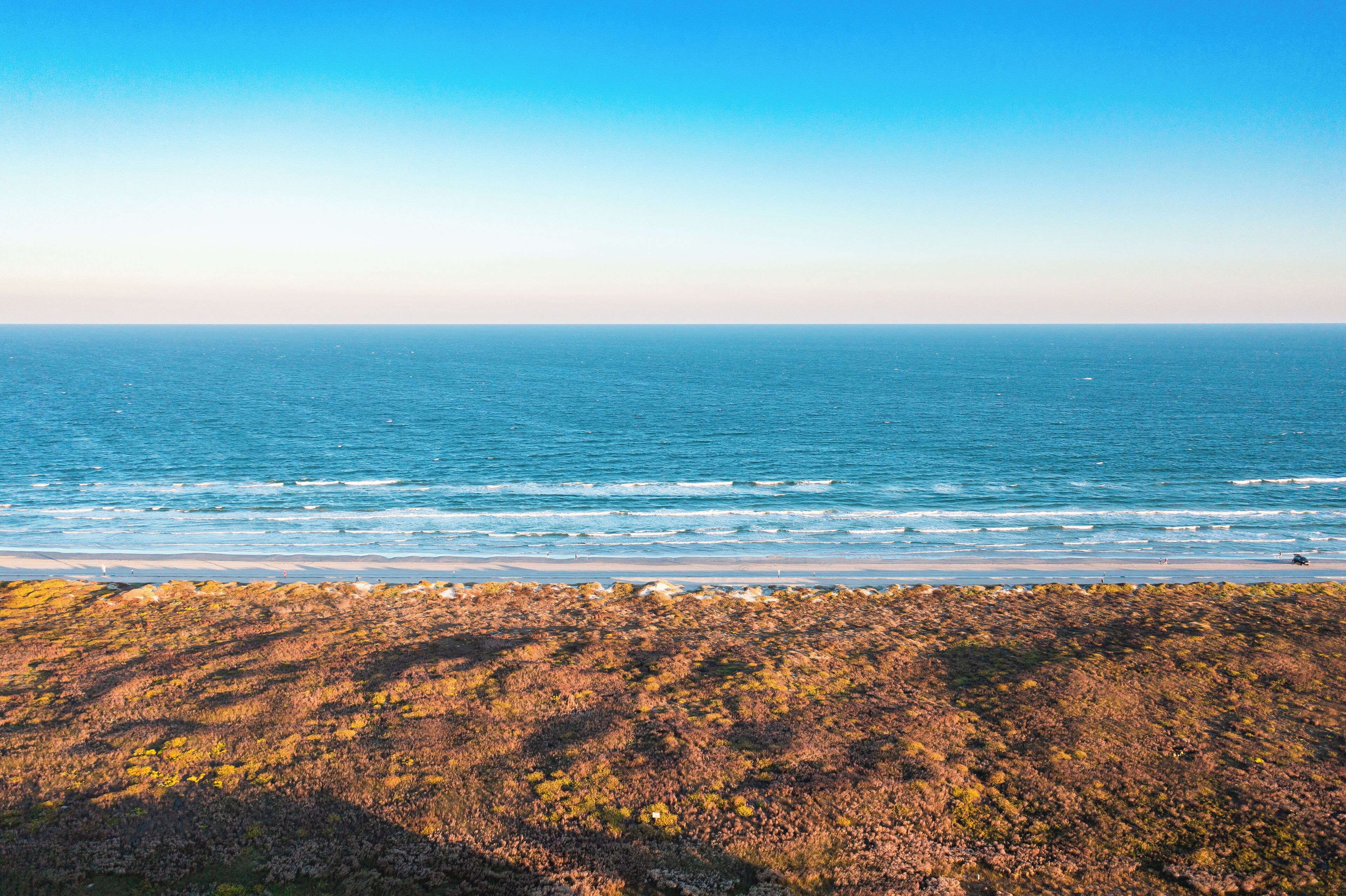 A coastal landscape with a view of the ocean and a rocky shoreline.