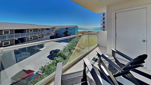 A balcony with a clear view of a parking lot and adjacent buildings. - Regency Towers #401 East | Gulf Front, Pool, Pickleball/Tennis (Pensacola Beach)