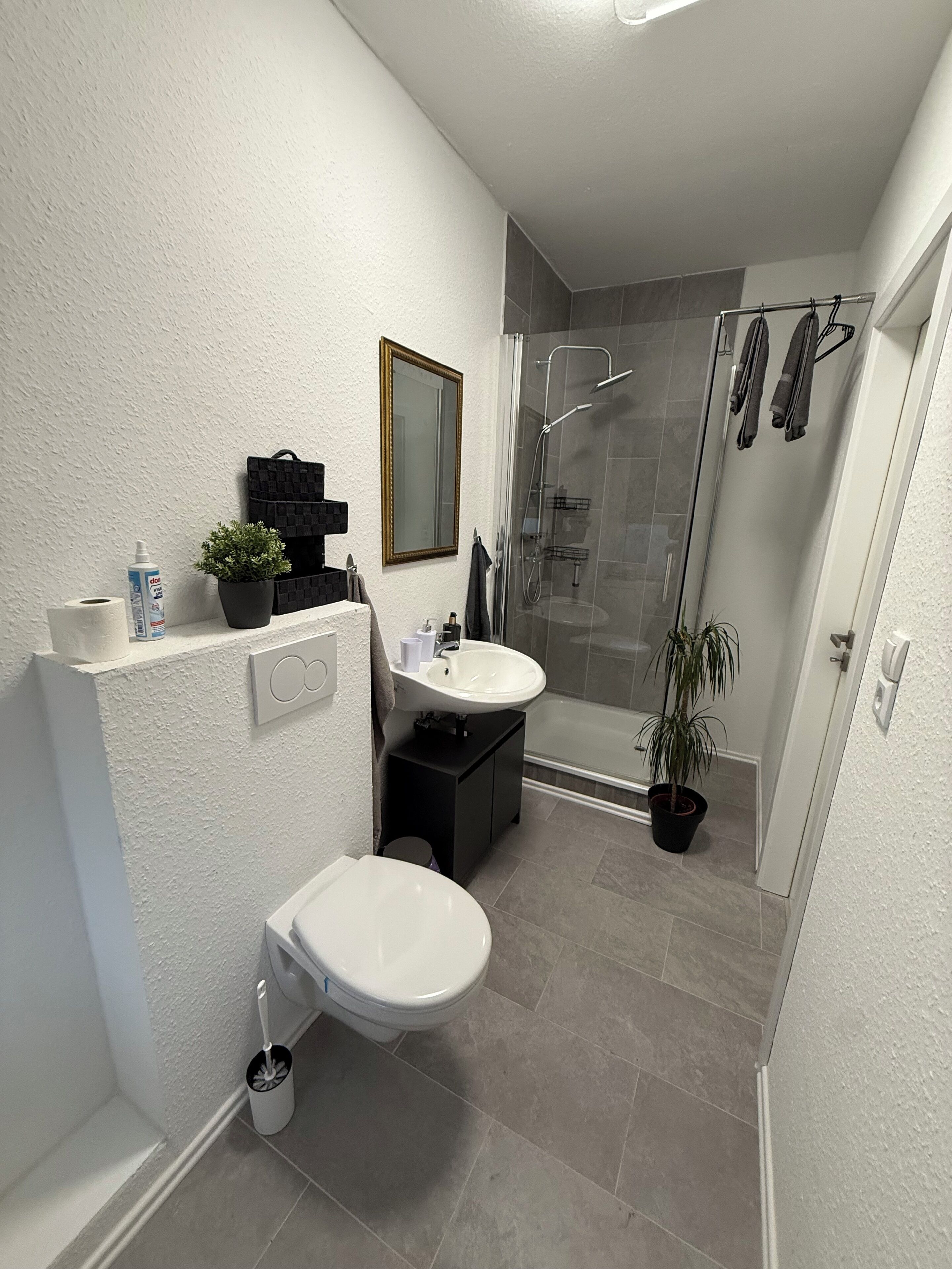 Een douche, handdoeken, zeep, toiletpapier