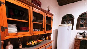 A kitchen with wooden cabinets, a white refrigerator, and a tiled floor. - Chácara Recanto da Coruja - São Pedro, SP (São Pedro)