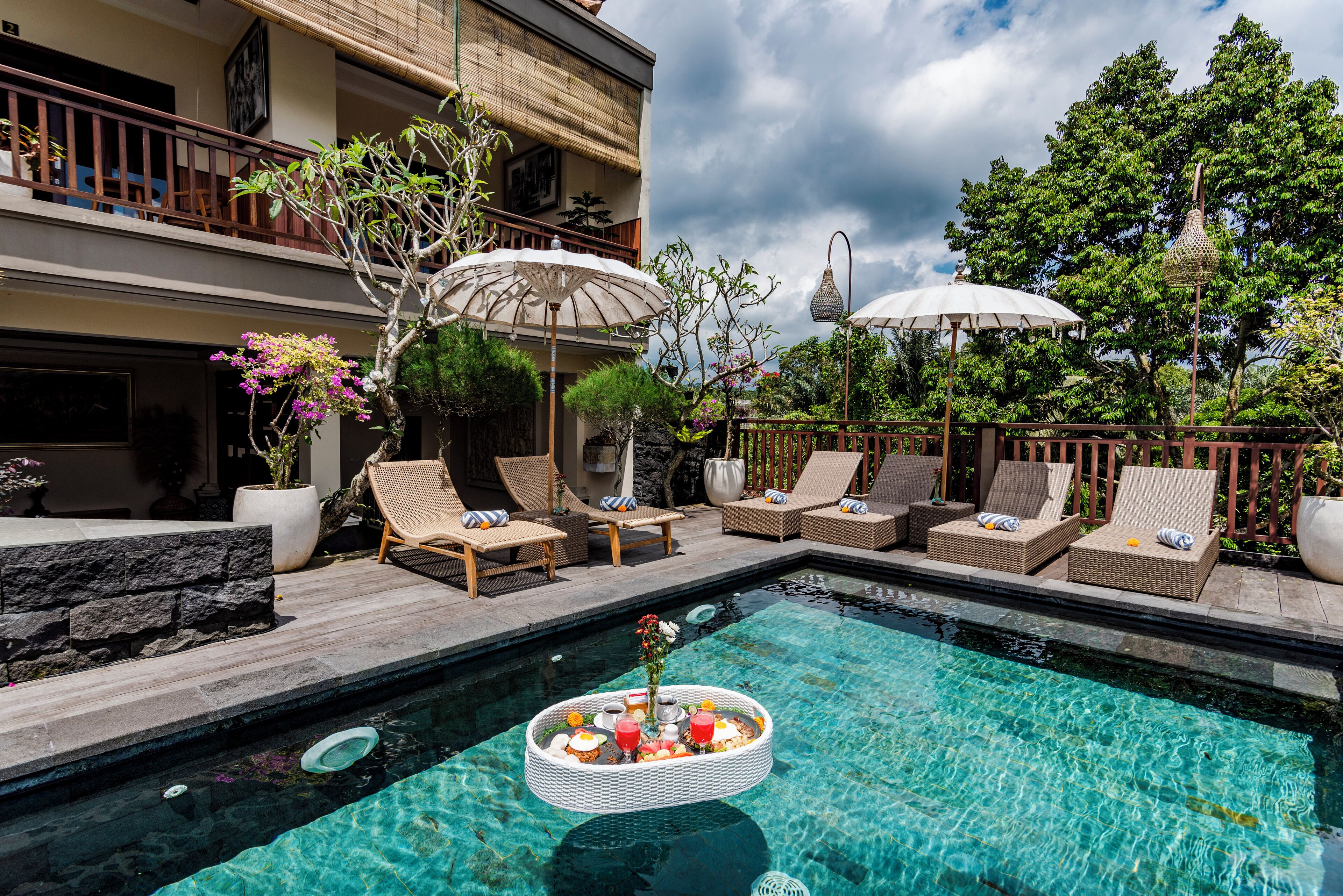 Una piscina al aire libre, sombrillas, tumbonas