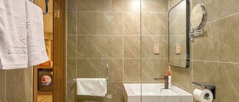 Une salle de bain moderne équipée d’une douche, d’un lavabo, de toilettes et d’un porte-serviettes.