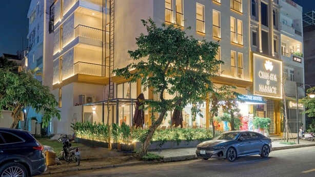 A hotel with a prominent sign, a massage center, and a well-lit facade. - BALVENIE HOTEL Phu My Hung SECC (Ho Chi Minh City)