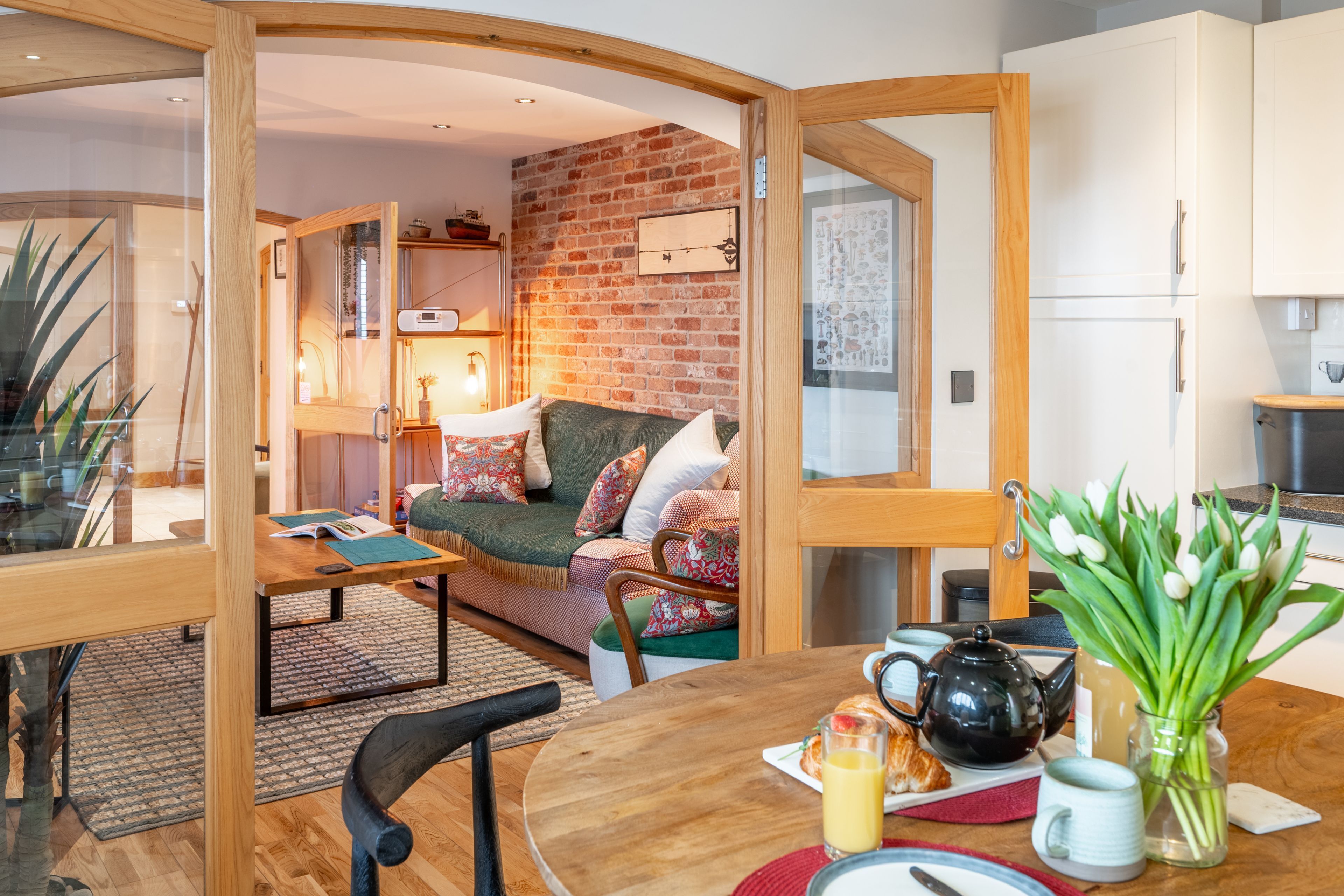 A cozy living area with a sofa, coffee table, and a dining table set with breakfast items.