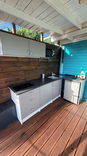 An outdoor kitchen with a built-in microwave, sink, and storage cabinets. - Bwaflo – Lodge with a hot tub in Martinique, an outdoor kitchen, and a beach within walking distance   (Sainte-Luce)