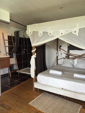A bedroom with a canopy bed, a wooden ladder, a shower, and a wooden floor. - Bwaflo – Lodge with a hot tub in Martinique, an outdoor kitchen, and a beach within walking distance   (Sainte-Luce)