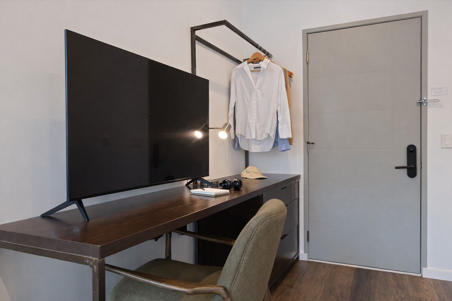 A modern office space with a desk, chair, and a large monitor.