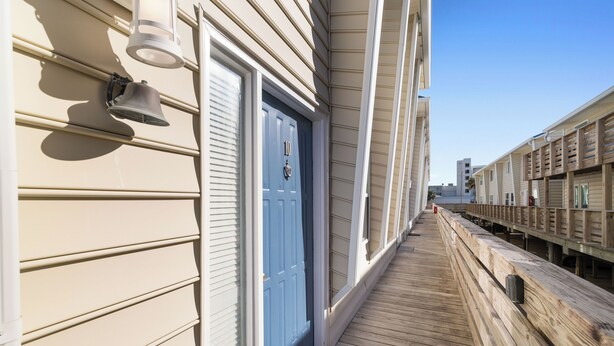 A wooden deck with a blue door and a mailbox. - Gulf View 10 by Liquid Life (Gulf Shores)