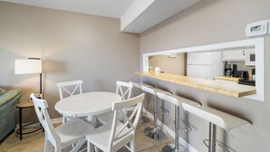A compact kitchen with a white countertop, a built-in microwave, and a coffee maker. - Gulf View 10 by Liquid Life (Gulf Shores)