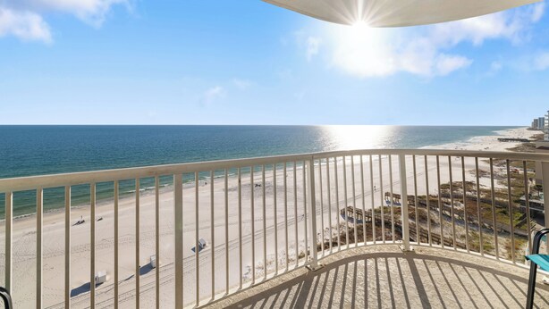 En balkon med udsigt over strand og hav.