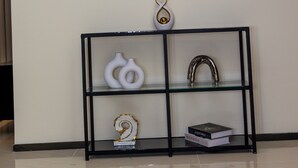 Una stanza con un tavolo consolle dal telaio nero che espone oggetti decorativi e libri.