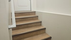 Eine Treppe mit Holzboden und einer weißen Tür am Oberende.
