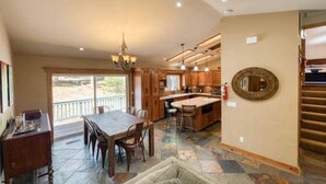 Una cocina amplia con una isla grande, armarios de madera y un comedor con mesa y sillas.