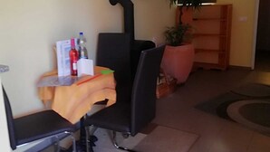 A small, cozy room with a dining area featuring a table, chairs, and a potted plant.