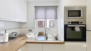 A modern kitchen with a sink, kettle, and a microwave. - Modern Central Apartment - South Costa, Nerja (Nerja)