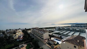 Zona residencial costera con edificios modernos, una carretera y vista al mar.