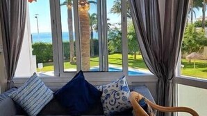 Habitación con vista a palmeras y una piscina.