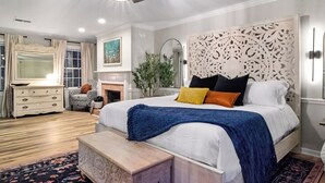 Ein Schlafzimmer mit einem großen Bett, einem Deckenventilator und einem Kamin.