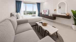 Una sala de estar moderna con un sofá, una mesa de comedor, un televisor y un cartel que dice 'BOOK ME'.