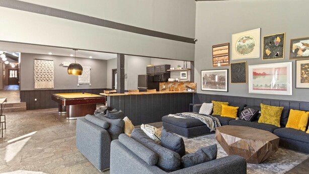 A modern living room with a pool table, grey sofas, and a dining area with a bar. - Cozy Mtn Retreat w/Fireplace | Mins to Village (Mammoth Lakes)
