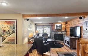 Ein gemütliches Wohnzimmer mit Kamin, Holzwänden und einem Fernseher.