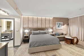 A modern hotel room with a large bed, bedside lamps, a sofa, a small table, and a mirror. - Cozy Studio w King Bed, Fireplace & Kitchenette (Mammoth Lakes)