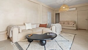 A living room with a sofa, a coffee table, a hanging light fixture, and a door. - Casa Angeles, Frontline Beach House (Torreguadiaro)