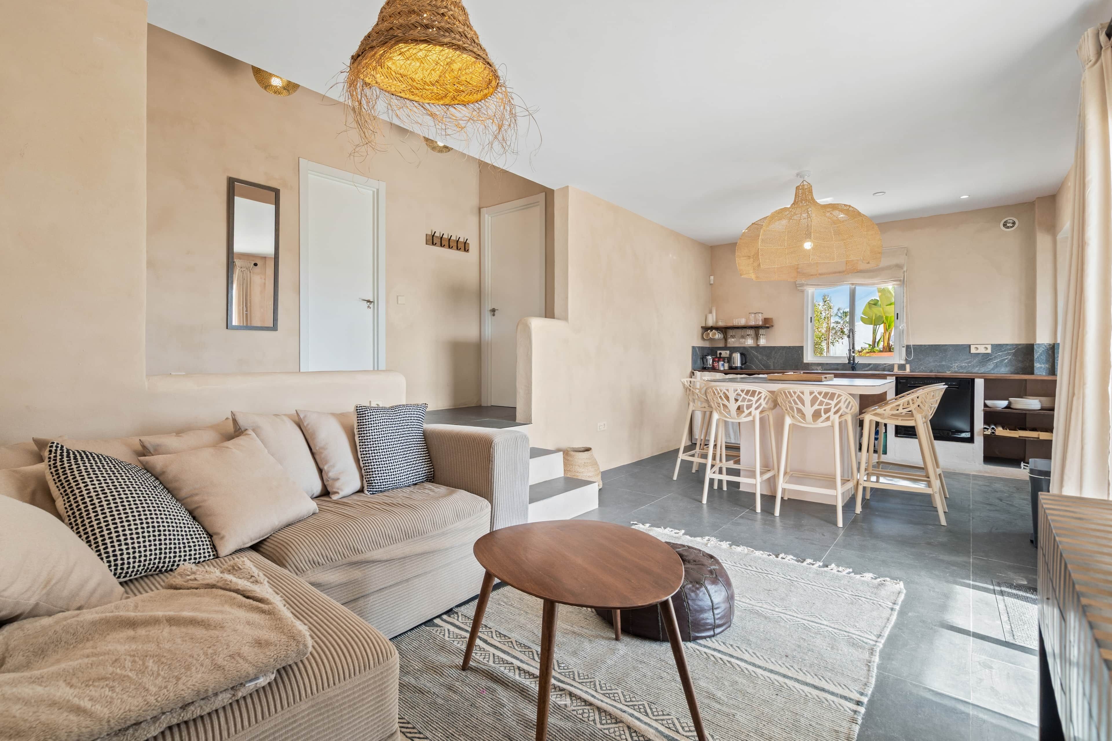 Un salon moderne comprenant un canapé, une table basse et un coin cuisine avec un ensemble de salle à manger.