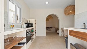 A modern kitchen with a large window, built-in appliances, and a central island. - Casa Rosa, Frontline Beach House (Torreguadiaro)