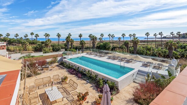 A rooftop pool with lounge chairs and a view of the beach. - Casa Rosa, Frontline Beach House (Torreguadiaro)