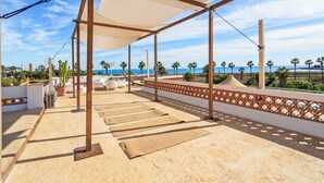 A rooftop terrace with a view of the sea, equipped with yoga mats and outdoor furniture. - Casa Rosa, Frontline Beach House (Torreguadiaro)
