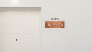 A white door with a metal handle and a sign above it that reads "CASA IBRAHIM" on a textured wall. - Casa Ibrahim, Frontline Beach House (Torreguadiaro)