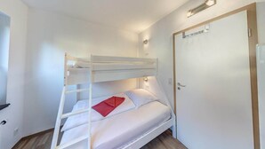 A bunk bed room with a door, a light fixture, and a wall socket. - Großzügige Ferienwohnung für bis zu 9 Personen (Burhave)