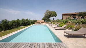 Une piscine rectangulaire avec des chaises longues et une terrasse en bois.