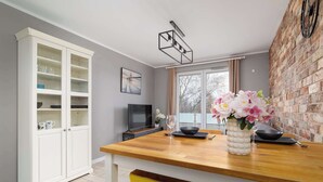 A modern kitchen with a wooden countertop, a white cabinet, and a brick wall. - Modern Apartment | 2 Bedrooms | Workspace | Katowice. (Katowice)