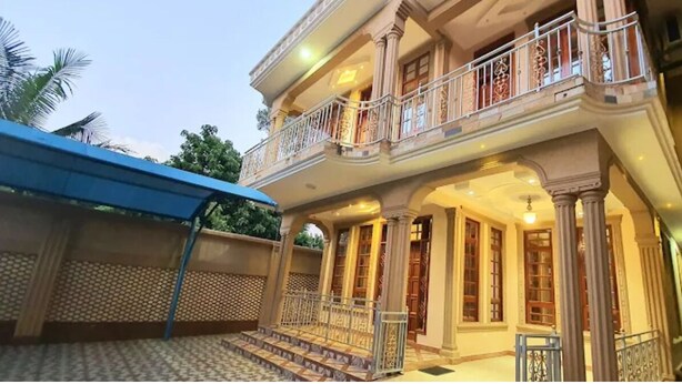 A two-story building with a balcony, columns, and a covered entrance. - Cape Villa (Arusha)