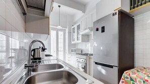 Eine moderne Küche mit Edelstahlgeräten, einer Spüle und einem Kühlschrank.