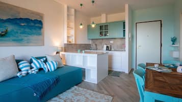 Deluxe appartement, uitzicht op zee | Privékeuken | Een microgolfoven, een kookplaat, kookgerei, borden en bestek